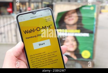 Ein Mann hält vor einem Wahlplakat der Partei Die Grünen/Bündnis 90 ein smartphone in der hand, auf dem der Wahl-O-Mat zur Bürgerschaftswahl in Hamburg geöffnet ist. Eppendorf Hambourg *** Un homme tient un smartphone devant une affiche électorale pour le Parti Vert Bündnis 90, sur laquelle le Wahl O Mat pour les élections législatives à Hambourg est ouvert Eppendorf Hambourg Banque D'Images