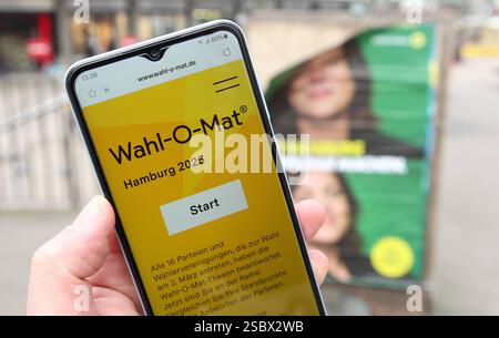 Ein Mann hält vor einem Wahlplakat der Partei Die Grünen/Bündnis 90 ein smartphone in der hand, auf dem der Wahl-O-Mat zur Bürgerschaftswahl in Hamburg geöffnet ist. Eppendorf Hambourg *** Un homme tient un smartphone devant une affiche électorale pour le Parti Vert Bündnis 90, sur laquelle le Wahl O Mat pour les élections législatives à Hambourg est ouvert Eppendorf Hambourg Banque D'Images