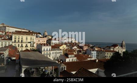 Vue panoramique sur les toits de Lisbonne depuis Alfama en été avec ciel bleu et rivière sur fond. Touristique Banque D'Images