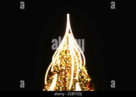 Lumières luisantes floues ressemblant à un arbre de vacances la nuit Banque D'Images