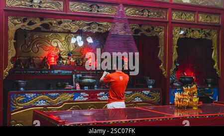 Balikpapan, Indonésie - 28 janvier 2025. L'homme en rouge prie pour accueillir le nouvel an chinois. Banque D'Images