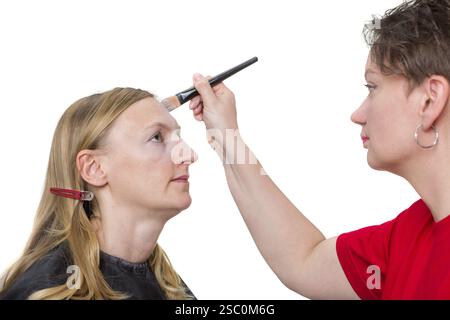 Gros plan d'un maquilleur appliquant le maquillage. Isolé sur fond blanc Banque D'Images