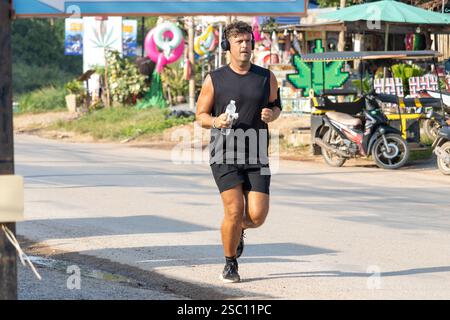 KOH LANTA, THAÏLANDE, DEC 02 2024, Un homme court le long de la route sur l'île de Koh Lanta Banque D'Images