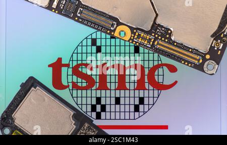 Londres. UK- 02.02.2025. Macro gros plan sur le signe du nom du fabricant taïwanais de semi-conducteurs TSMC avec des puces et des pièces d'un smartphone. Banque D'Images