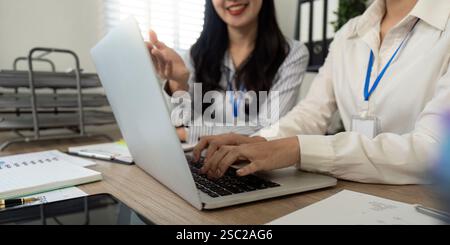 Équipe commerciale diversifiée collaborant et partageant des informations sur un ordinateur portable lors d'une réunion. Banque D'Images