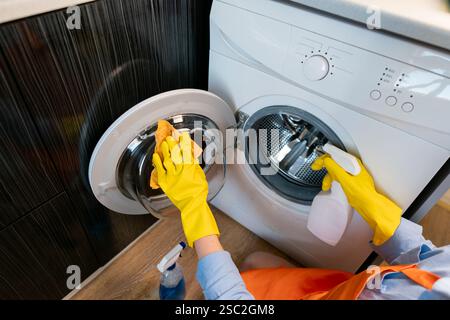 Le nettoyage régulier de la machine à laver empêche les traces de saleté et les résidus de détergent sur les vêtements après le lavage. Banque D'Images