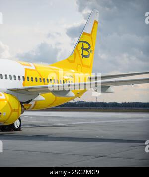 Partie arrière du Boeing 737 Bees Passenger (UR-UBA) à l'aéroport. Section de queue d'un avion blanc n jaune avec une livrée sur le thème du nid d'abeilles sur le tablier. Banque D'Images