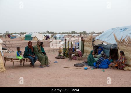 Camp de réfugiés maliens de Mentao, près de Gibo, dans le nord du Burkina Faso mai 2012 : les gens se rassemblent dans la fraîcheur relative de la fin de l'après-midi. Les réfugiés, pour la plupart Touaregs, sont aujourd’hui plus de 60 000 au Burkina Faso seulement, et continuent d’arriver quotidiennement dans les camps, suite au chaos politique créé par le coup d’État du 22 mars 2012 par des officiers maliens subalternes. Photographie de Mike Goldwater Banque D'Images