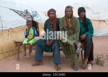 Camp de réfugiés maliens de Mentao, près de Gibo, dans le nord du Burkina Faso mai 2012 : les gens se rassemblent dans la fraîcheur relative de la fin de l'après-midi. Les réfugiés, pour la plupart Touaregs, sont aujourd’hui plus de 60 000 au Burkina Faso seulement, et continuent d’arriver quotidiennement dans les camps, suite au chaos politique créé par le coup d’État du 22 mars 2012 par des officiers maliens subalternes. Photographie de Mike Goldwater Banque D'Images