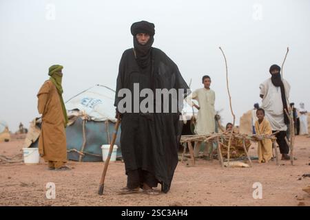 Camp de réfugiés maliens de Mentao, près de Gibo, dans le nord du Burkina Faso mai 2012 : les gens se rassemblent dans la fraîcheur relative de la fin de l'après-midi. Les réfugiés, pour la plupart Touaregs, sont aujourd’hui plus de 60 000 au Burkina Faso seulement, et continuent d’arriver quotidiennement dans les camps, suite au chaos politique créé par le coup d’État du 22 mars 2012 par des officiers maliens subalternes. Photographie de Mike Goldwater Banque D'Images