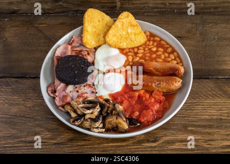 Petit déjeuner anglais complet avec saucisses, bacon, œufs, pudding noir, haricots, tomates et champignons Banque D'Images