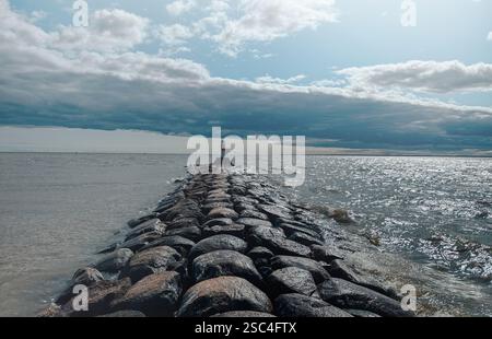 Un phare se dresse sur un rocher face à la mer Banque D'Images
