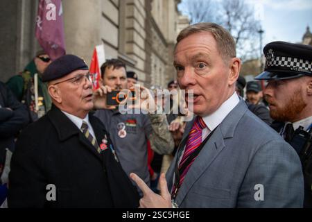 Londres, Royaume-Uni, 5 février 2025. Député travailliste de Rhondda et Ogmore, Chris Bryant affronte un vétéran militaire lors d'une manifestation devant un bâtiment du gouvernement à Londres. Après avoir essayé de se frayer un chemin devant plusieurs anciens militaires, il a ensuite été repoussé aux cris du traître. Il a ensuite été escorté autour de la manifestation par des policiers. Des vétérans militaires organisent une manifestation dans le centre de Londres contre ce qu'ils appellent la persécution historique vexatoire des anciens militaires pendant les troubles de l'Irlande du Nord. Crédit : James Willoughby/ALAMY Live News Banque D'Images