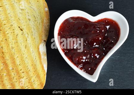 Confiture de fraises dans un bol en forme de coeur Banque D'Images