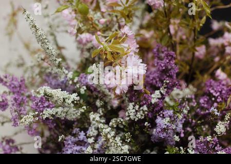 Un bel arrangement de fleurs roses et violettes remplit un vase décoratif. Les différentes fleurs présentent des textures délicates et des couleurs riches, améliorant t Banque D'Images