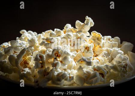 Gros plan de pop-corn fraîchement éclaté sur fond noir Banque D'Images