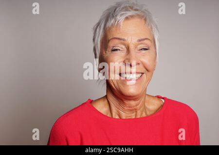 femme âgée heureuse avec les cheveux gris courts riant Banque D'Images