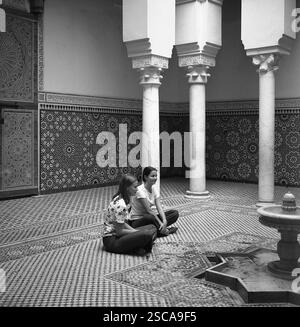 Les femmes assises sur le sol en face d'une fontaine dans un palais à Meknès au Maroc. Banque D'Images