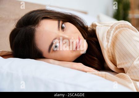 Une charmante jeune femme se détend de son côté, regardant ludique le spectateur en paix. Banque D'Images
