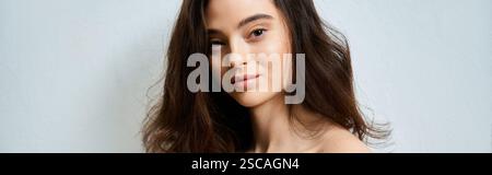 Une jeune femme gracieuse pose à l'intérieur, soulignant ses charmantes traits et son sourire radieux. Banque D'Images