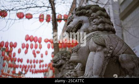 Chinatown Street à londres avec statue de lion en pierre et lanternes rouges suspendues en hiver. Banque D'Images