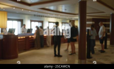 Image défocalisée de personnes dans une luxueuse salle de croisière avec un arrière-plan bokeh flou, représentant des hommes et des femmes à l'intérieur dans une zone de réception, capturant un Banque D'Images