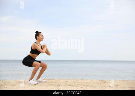 Jeune femme faisant de l'exercice sur la plage, espace pour le texte. Entraînement du corps Banque D'Images