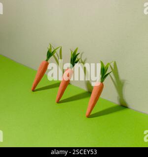 Carottes sur fond vert et gris. Concept minimal de Pâques. Printemps composition minimale Banque D'Images