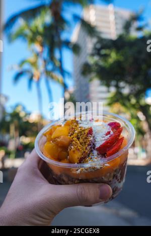 Main tenant Acai Bowl avec des fruits tropicaux dans le cadre urbain d'Hawaï Banque D'Images