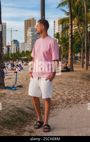 Homme sur Sandy Beach avec des palmiers et paysage urbain en arrière-plan Banque D'Images