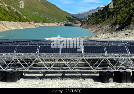 Les panneaux solaires de la première centrale solaire alpine flottante se trouvent à marée basse sur les rives du réservoir du Lac des Toules, Valais, Suisse Banque D'Images