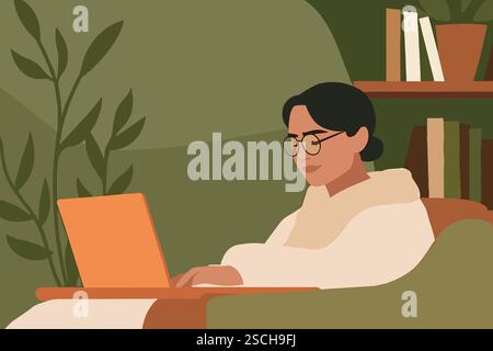 Une femme est assise confortablement dans un coin confortable, travaillant sur son ordinateur portable. Entourée de plantes et de livres, elle est concentrée et engagée dans ses tâches. Banque D'Images