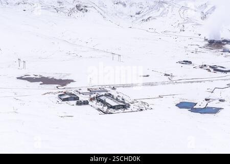 Vue aérienne d'un site industriel émettant de la vapeur dans un paysage enneigé près de Reikiavik, Islande, mettant en évidence le contraste entre l'industrie et la nat Banque D'Images