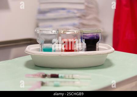 Une vue détaillée de l'équipement de laboratoire utilisé dans un hôpital, présentant plusieurs flacons de test avec des solutions colorées et des seringues, indiquant un w Banque D'Images