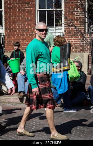 Man in kilt, défilé de Patrick's Day, distribuant des seaux verts. Banque D'Images