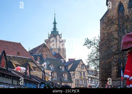 Marché de Noël dans les ruelles de la vieille ville historique et Saint Martin's Minster en arrière-plan, Colmar, département du Haut-Rhin, Alsace, France. Banque D'Images