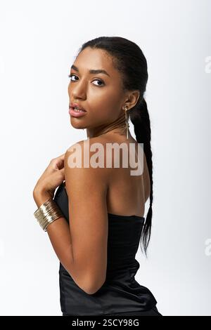 Jeune femme belle mettant en valeur un style vestimentaire chic dans un cadre à la mode avant-gardiste. Banque D'Images
