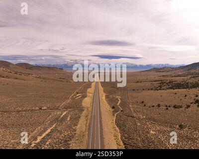 La route la plus solitaire du Nevada, route 50, vue aérienne, nuages passant au-dessus des montagnes avec de la neige, paysage désertique Banque D'Images