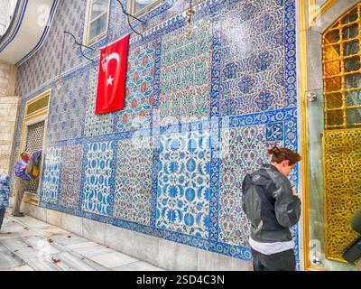 Istanbul - sep 22, 2024 - touriste admirant les tuiles colorées d'iznik décorant le mur extérieur de la mosquée du sultan eyup à istanbul, turquie, avec un Banque D'Images