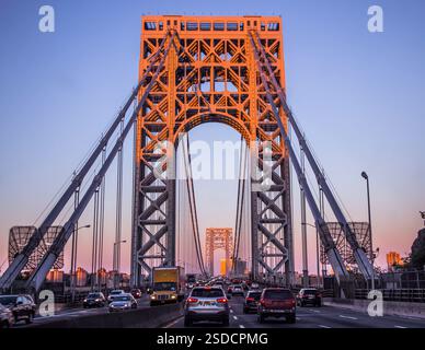 Les véhicules traversent le pont George Washington aux heures du coucher du soleil. Banque D'Images