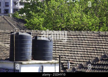 Dessus de réservoir d'eau sur le toit de boue de chawl de vieux bâtiment, Mahalakshmi, Maharashtra, Inde, Asie Banque D'Images