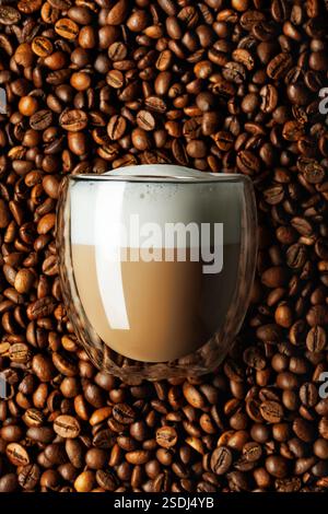 cappuccino en verre et grains de café comme fond Banque D'Images