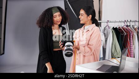 Personnes, appareil photo et planification pour photoshoot sur le plateau, collaboration et instructions pour la prise de vue. Femmes, photographe et parler à styliste pour Banque D'Images