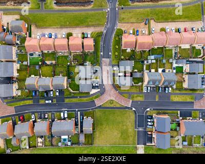 Vue aérienne de haut en bas au-dessus d'un bloc de maisons de banlieue abordables nouvellement construites sur le bord d'un village au Royaume-Uni avec de petits jardins Banque D'Images