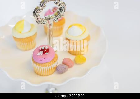 Cupcakes à la fraise et au citron sur un stand de gâteau traditionnel pour le thé de Pâques et l'après-midi ; concept pour le thé, les anniversaires et la fête des mères. Banque D'Images