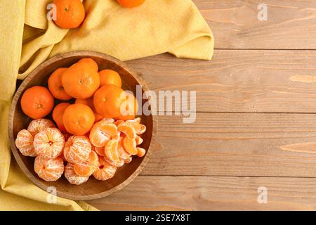 Bol avec tangerines sucrées sur table en bois Banque D'Images