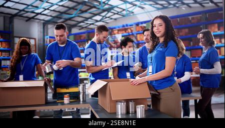 Divers bénévoles de la fondation caritative emballent des dons alimentaires pour la communauté. Banque D'Images