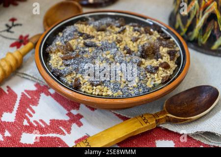Kutia de Noël avec graines de pavot et raisins secs. Cuillère en bois. Céréales sucrées traditionnelles Kutya dans Ceramic Bowl porridge. Banque D'Images