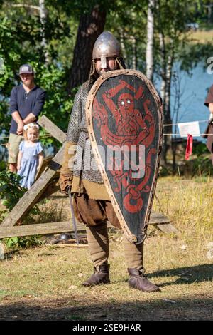 Reconstitueur avec casque nasal, armure de mailles à chaîne et bouclier de cerf-volant au spectacle de reconstitution du marché de l'âge de fer de Pukkisaari à Helsinki, en Finlande Banque D'Images