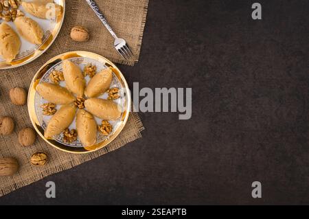 La célèbre halva de farine traditionnelle maison turque servie avec de la noix en plaque sur fond rustique, dessert turc pour la nuit Sainte ou les funérailles Banque D'Images